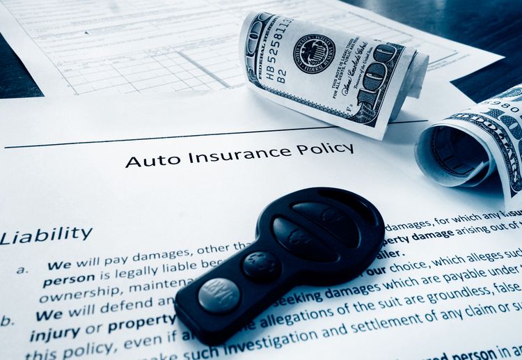 auto insurance policy with cash on table
