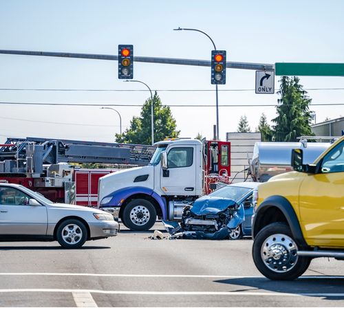 Image is of an auto accident of a car with a semi truck in the middle of an intersection, concept of Lewisville truck accident lawyer